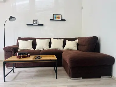 a brown couch in a living room with a coffee table at Classic Modern Apartment with Parking Place in Sofia
