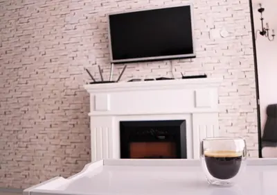 a glass of wine sitting on a table in front of a fireplace at The White Apartment 3BR - free parking in Sofia