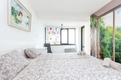 a white bedroom with a large bed and a window at The White Apartment 3BR - free parking in Sofia