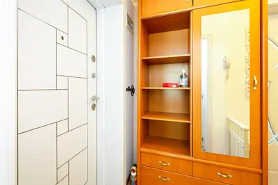 a closet with a wooden cabinet and a mirror at The White Apartment 3BR - free parking in Sofia