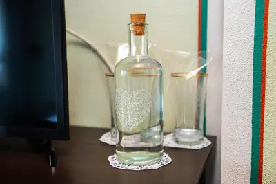 a bottle of water on a table with two glasses at Къща ЕТНО in Koprivshtitsa