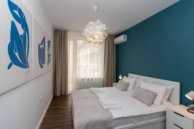 a bedroom with a large bed with a blue wall at Central Sofia Condo in Sofia