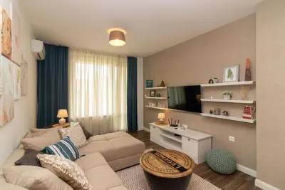 a living room with a couch and a tv at Central Sofia Condo in Sofia