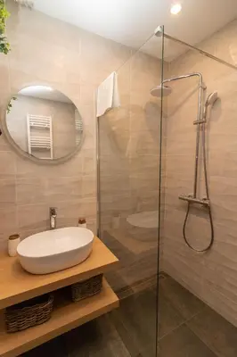 a bathroom with a sink and a glass shower at Central Sofia Condo in Sofia