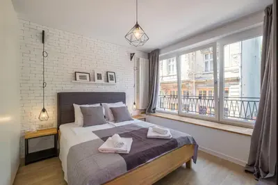 a bedroom with a bed and a large window at Industrial Look Apartment Top Centre + Free Parking in Sofia