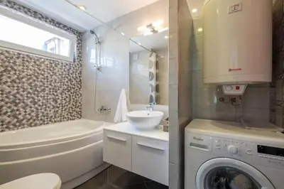 a bathroom with a sink and a washing machine at Industrial Look Apartment Top Centre + Free Parking in Sofia