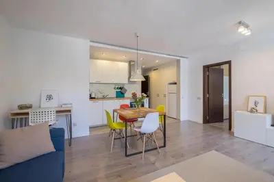 a living room and kitchen with a table and chairs at Quiet & airy modern apt. Top Centre Free Parking in Sofia