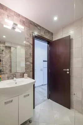 a bathroom with a sink and a wooden door at Quiet & airy modern apt. Top Centre Free Parking in Sofia