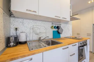 a kitchen with white cabinets and a sink at Quiet & airy modern apt. Top Centre Free Parking in Sofia