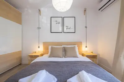 a bedroom with a large bed with two tables at Quiet & airy modern apt. Top Centre Free Parking in Sofia