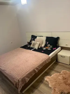 a bedroom with a bed and a brown rug at Guest House Amaya Med in Plovdiv