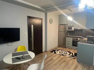a small apartment with a table and a kitchen at Guest House Amaya Med in Plovdiv