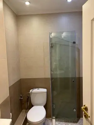 a bathroom with a toilet and a glass shower at Guest House Amaya River in Plovdiv