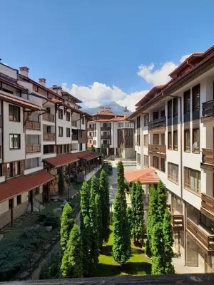 an apartment complex with a courtyard with trees and buildings at Ski-in ski-out Fantastic Apartament in Bansko