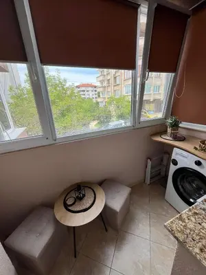 a small kitchen with a table and two windows at Studio John's in Blagoevgrad
