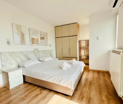 a bedroom with a large white bed and wooden floors at Apart-Hotels-Sofia, AHS in Sofia