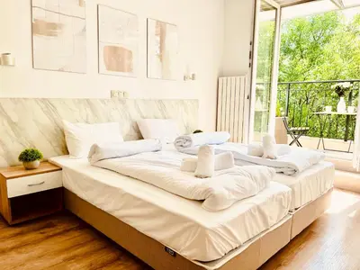 two beds in a room with a large window at Apart-Hotels-Sofia, AHS in Sofia