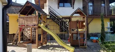 a playground with a slide and a play structure at Three Graces in Banya