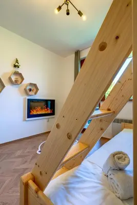 a bedroom with a bunk bed with wooden stairs at Villa Kometa Pamporovo Cozy 1-BD Flat by Flat Mаnager in Pamporovo