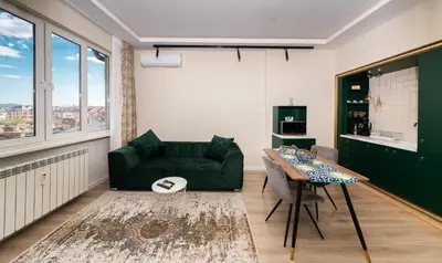 a living room with a green couch and a table at Heart of the Center, 2Bedroom View Lux Apartment in Sofia