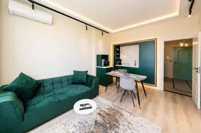 a living room with a green couch and a table at Heart of the Center, 2Bedroom View Lux Apartment in Sofia