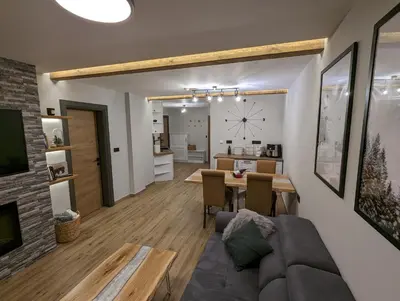 a living room with a couch and a table at Pine & Wine Bathtub Apartment in Pamporovo