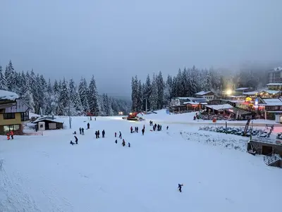 a group of people skiing down a snow covered slope at Pine & Wine Bathtub Apartment in Pamporovo