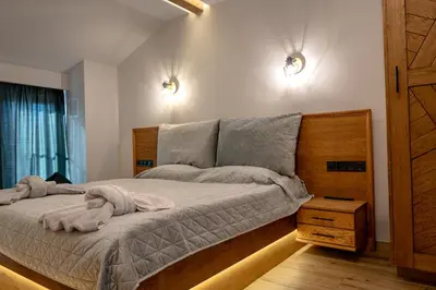 a bedroom with a bed with two towels on it at Pine & Wine Bathtub Apartment in Pamporovo