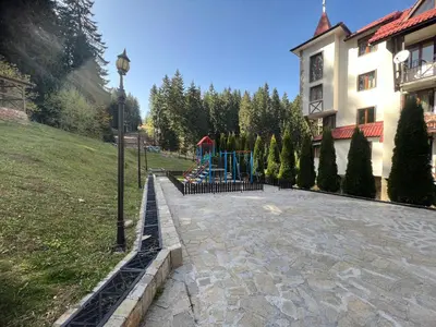 a playground in a yard next to a building at Minkov Apartments, Пампорово - Замъка 2 in Pamporovo
