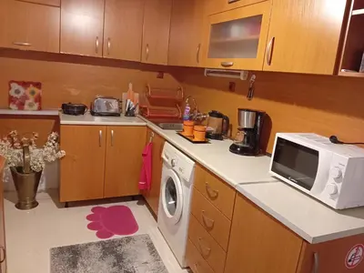 a kitchen with a washing machine and a microwave at Апартамент Стела in Sofia