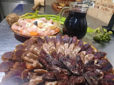 a table with a plate of food and a bowl of food at Парк - Хотел Макензен in Melnik