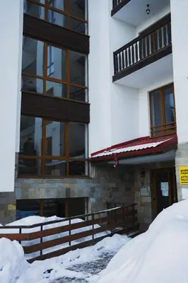 a building with snow in front of it at Sunny studio in Pamporovo in Pamporovo