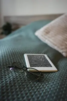 a pair of glasses sitting on top of a bed at Sunny studio in Pamporovo in Pamporovo