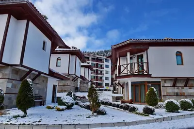 a group of buildings with snow on the ground at Forest Nook Villas in Pamporovo