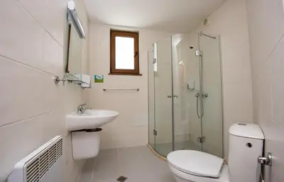 a bathroom with a toilet and a sink and a shower at Forest Nook Villas in Pamporovo
