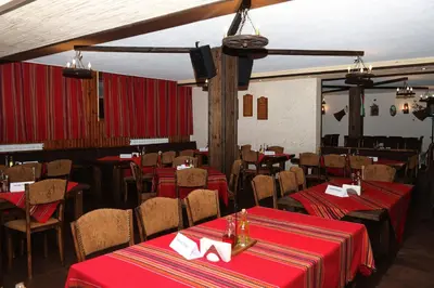 a restaurant with tables and chairs with red table cloth at Forest Nook Villas in Pamporovo
