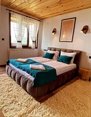 a large bed in a bedroom with a large bed sidx sidx at Rooms in Leshten in Leshten