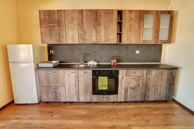 a kitchen with wooden cabinets and a sink and a refrigerator at Етно комплекс 