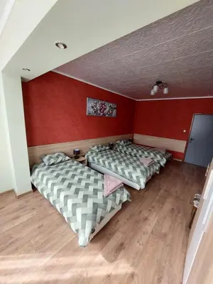two beds in a room with red walls at Familia Apartments in Samokov