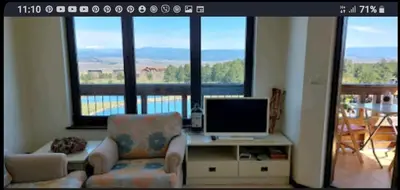 a living room with a tv and a couch and a chair at ALL VIEW in Golf Resort in Razlog