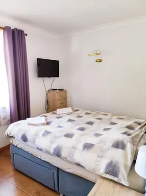 a bedroom with a bed and a tv on the wall at Терасите - Къща 1 in Ribarica