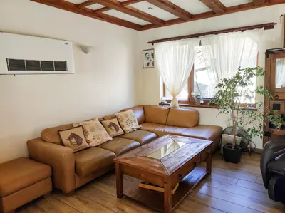 a living room with a brown couch and a coffee table at Терасите - Къща 1 in Ribarica