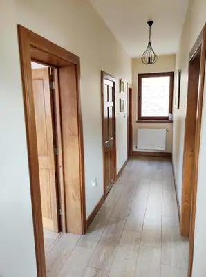 an empty hallway with wooden doors and a window at Терасите - Къща 2 in Ribarica