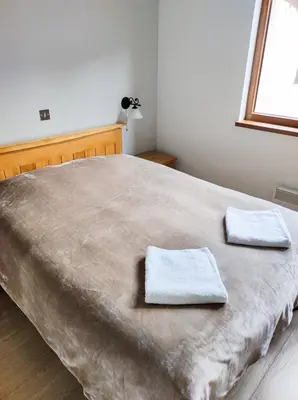 a bedroom with a large bed with two towels on it at Терасите - Къща 2 in Ribarica
