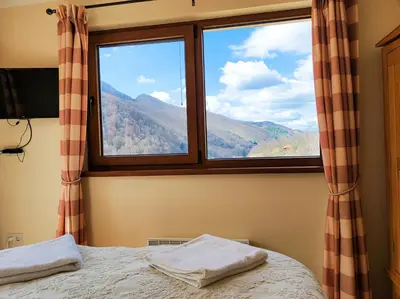 a bedroom with a window with a mountain view at Терасите - Къща 3 in Ribarica