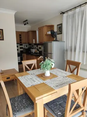 a kitchen with a wooden table with a vase of flowers on it at Терасите - Къща 4 in Ribarica
