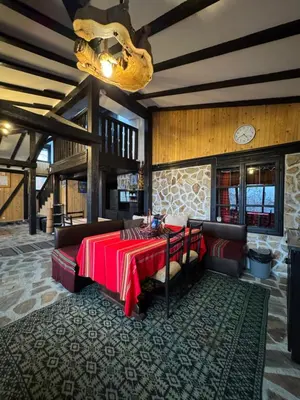 a dining room with a table with a red table cloth at СТАРАТА КЪЩА in Sovolyano