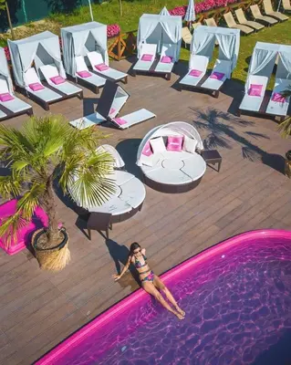 a woman in a bikini standing next to a swimming pool at The Wind Mills Hydropark in Gorna Malina