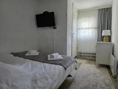 a bedroom with a bed and a tv on the wall at Къща ВИРА in Yasă-Koriya