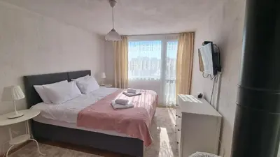 a bedroom with a bed with a pink blanket and a window at Къща ВИРА in Yasă-Koriya